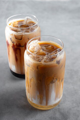 A view of some cold coffee latte beverages in can shaped glasses.