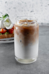 A view of a French vanilla coffee beverage in a can shaped glass.