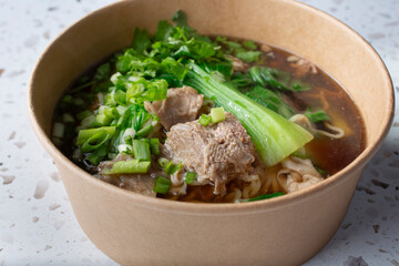 A closeup view of a beef noodle soup.