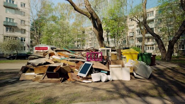 Debris and furnature dumbed at junkyard next to rubbish bin