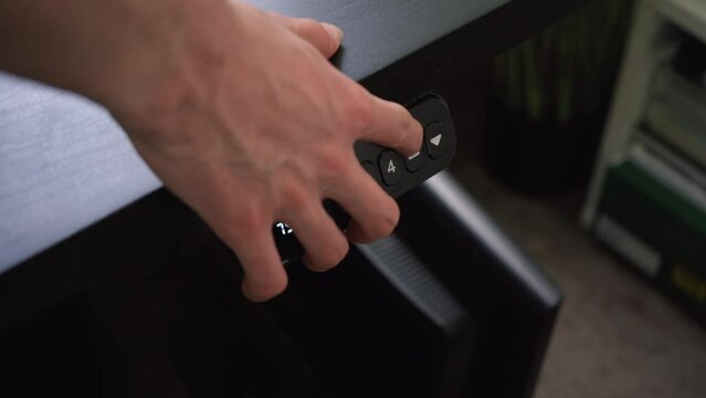 Steady shot of an adjustable desk moving toward a higher setting.