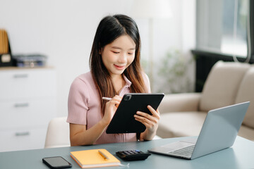 Asian woman sitting at a desk using a laptop computer Navigating Finance and Marketing with Technology