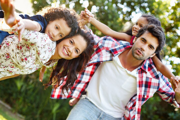 Happy family, portrait and piggyback kids at park for holiday, vacation or bonding together with parents in summer. Face, mother and father carry children in garden for support, love and playing game