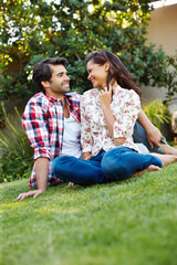 Outdoor, bonding and love for couple, grass and happy in backyard, relax and romance for people in home. Nature, man and woman on ground in park, smile and peace for marriage, honeymoon and rest