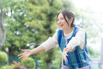 Also for main visuals! Image of a nursery school teacher doing “Come here” against a beautiful...