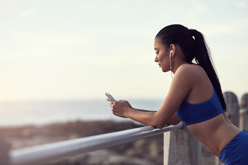 Girl, phone and music with fitness outdoor at promenade with break from exercise, workout and...