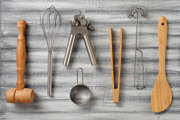 Close-up a different kitchen utensils, wooden and metal, on a beautiful wooden background.