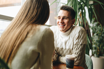 Smiling Man Engaged in a Casual Conversation at a Cozy Cafe During Daytime