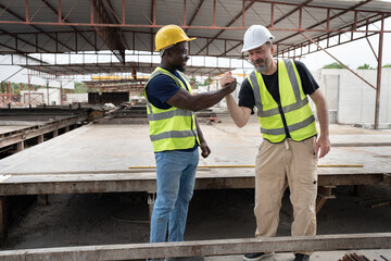Portrait African American engineer man hand shake with caucasian engineer man at precast cement...