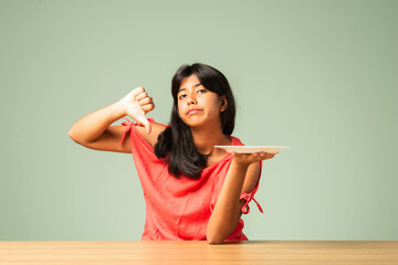 Indian asian small girl child saying no thanks to empty food plate