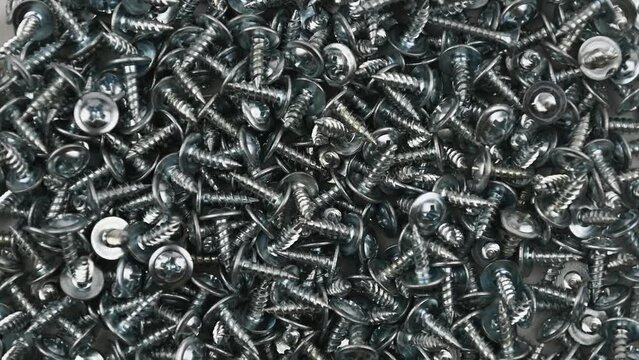 Self-tapping screws with press washer. Movement with rotation. Close-up, flat lay, top view. 4,2mm x 20mm.