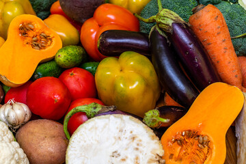 Various vegetables are laid out on a wooden table. Large assortment of vegetables food. pumpkin cabbage broccoli pepper tomatoes carrots and others