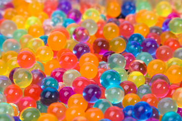 Hydrogel colored transparent balls orbeez, colorful background. Selective focus.