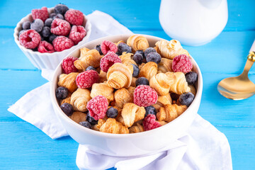 Tiny breakfast croissant cereals with fresh berries and milk