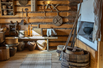 Kitchen utensils in the old house. Antique tableware and household items on the wall of a wooden...