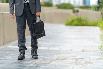 Confidence Asian businessman office worker in suit holding briefcase walking city street at office...
