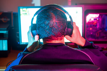 A gamer adjusting his headset, preparing for an immersive gaming session