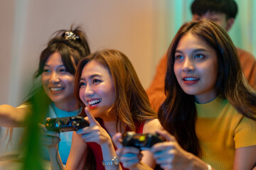 Group of Young Asian man and woman playing video games console together in living room at home....