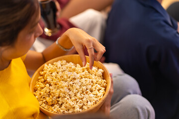 Group of Young Asian man and woman friends watching movie on television together in living room at...