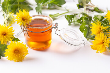 Dandelion honey and fresh flowers on white background. Close up