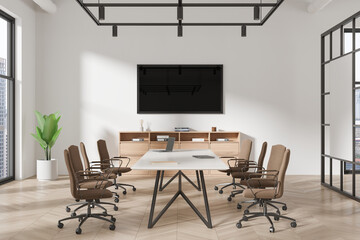 Stylish office interior with meeting table and chairs, tv screen and window