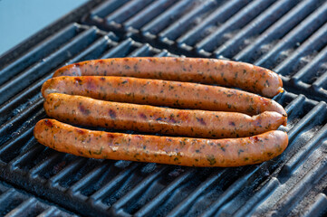 Four spiced sausages heated on gas grill