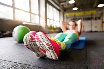 Beautiful sport woman exercising on gym mat with medicine ball. Routine workout for woman's...
