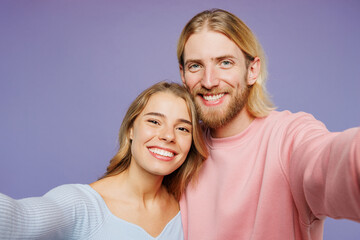 Close up young couple two friends family man woman wear pink blue casual clothes together doing selfie shot pov on mobile cell phone isolated on pastel plain light purple background studio portrait.