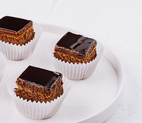 Chocolate glazed mini cakes on white plate