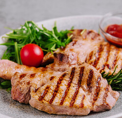 Grilled pork chops on ceramic plate with herbs