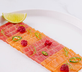 Fresh salmon sashimi plate with lime and herbs