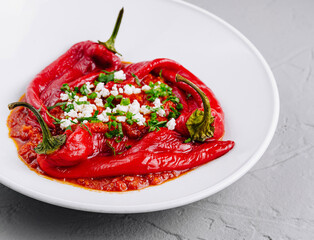 Roasted red peppers with feta cheese on white plate