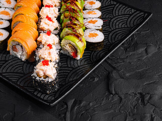 Assorted sushi platter on black background