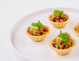 Fresh veggie tartlets on white plate