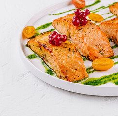 Grilled salmon fillets with berries and pesto sauce