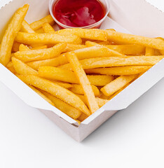 Crispy french fries in a takeout box with ketchup