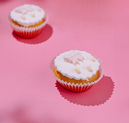 Pink delight: frosted cupcakes on pink background