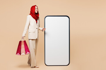 Young Asian Muslim woman wear red abaya hijab suit clothes shopping hold package bag big huge blank...