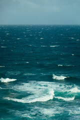 Moody stormy blue ocean with windy onshore waves and whitecaps captured from high above