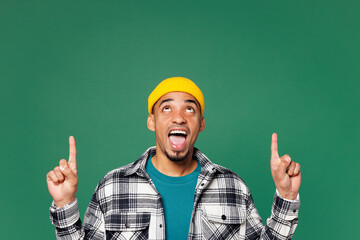 Young shocked man of African American ethnicity he wear shirt blue t-shirt yellow hat point index...