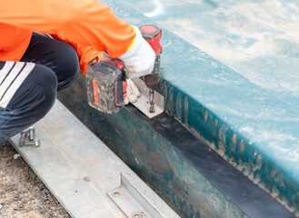 Worker uses cordless drill driver on rubber gasket.