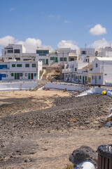 Fototapeta premium Typical white houses of the village of Caleta de Caballo. Dirt street and boats on the ground. Lanzarote, Canary Islands, Spain