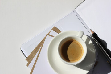 Espresso Closeup on Open Notebook with Blank Sheets, Cards, Pen and Pencil on White Workspace Background. Minimal Business Mockup.