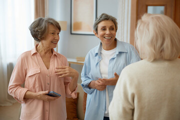 Obraz premium Elderly women friends laughing at home living room