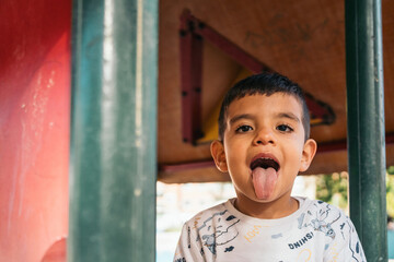 Playful boy sticking out tongue on playground