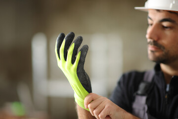 Construction worker putting a yellow protection glove