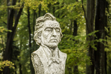 bust of Frederic Chopin against the background of leafy trees in a city park