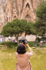 A tourist from behind looking at the Basilica of the Sagrada Familia in Barcelona, Spain