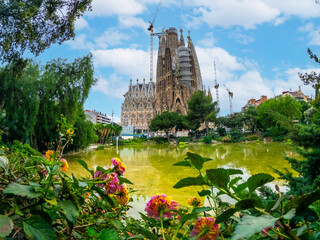 Basilica of the Sagrada Familia in Barcelona by the lake on a spring morning, Spain