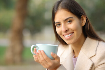 Happy woman with perfect smile in winter with coffee cup